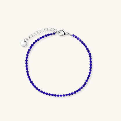 Slim stainless steel tennis bracelet set with vivid cobalt blue round zircon stones and a lobster clasp with extender chain.