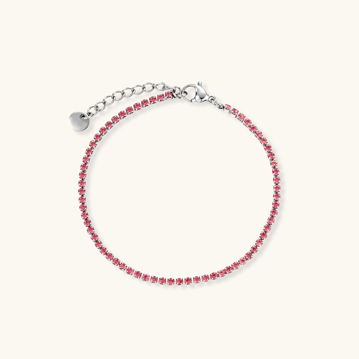 Pink zircon tennis bracelet with silver-tone stainless steel setting and lobster clasp extender chain, flat lay.