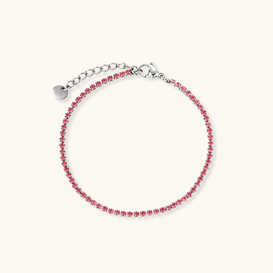 Pink zircon tennis bracelet with silver-tone stainless steel setting and lobster clasp extender chain, flat lay.
